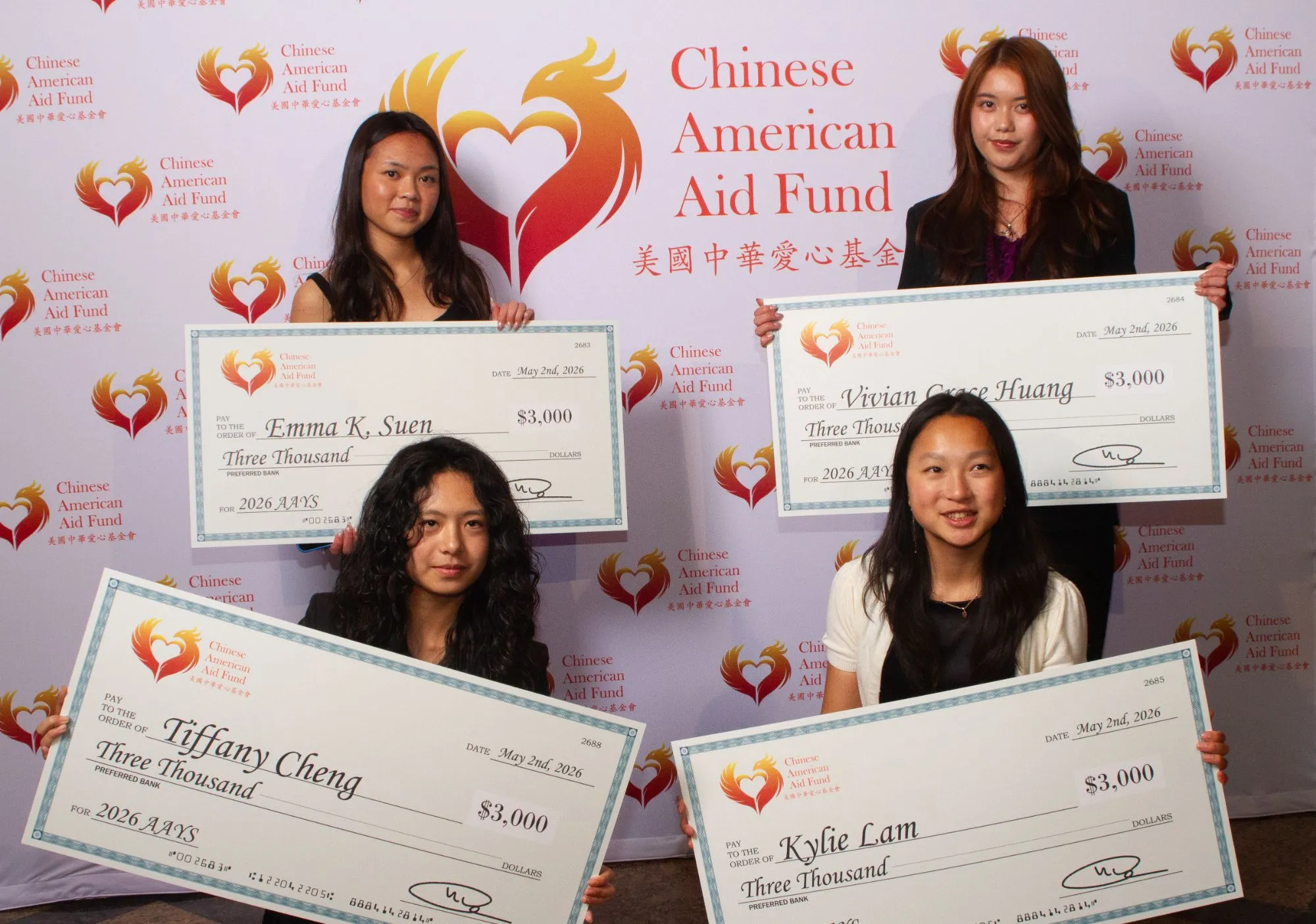 Quatre jeunes posent devant un fond portant le nom Chinese American Aid Fund et tiennent de grands chèques de 3 000 dollars.