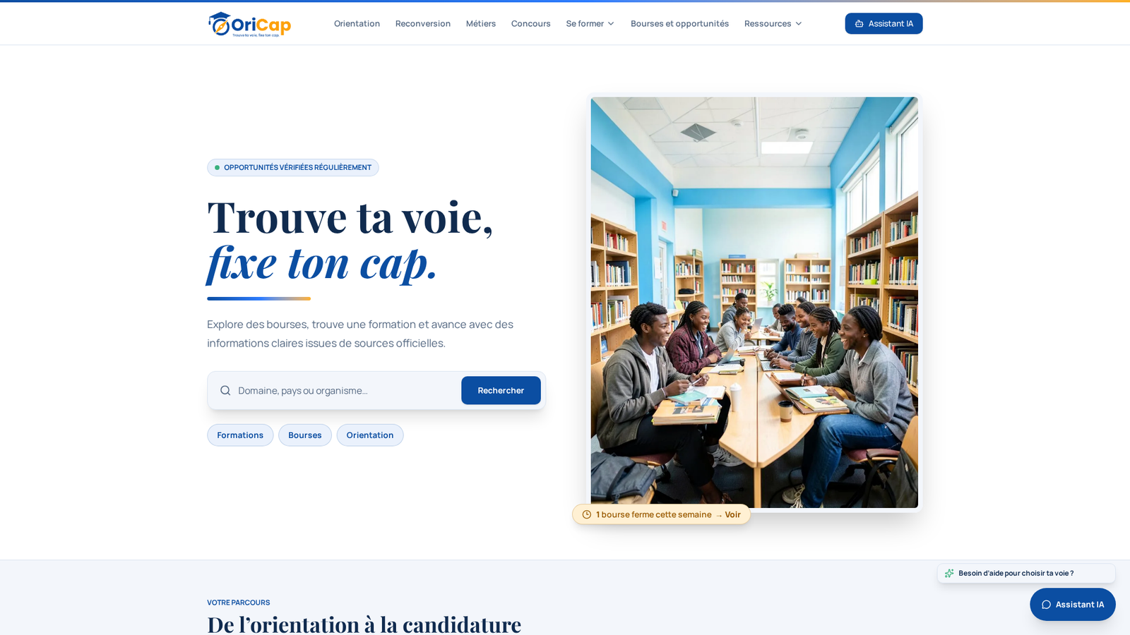 Des étudiants travaillent ensemble autour de tables dans une bibliothèque, entourés de rayonnages remplis de livres.