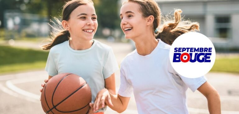 Deux jeunes femmes souriantes portant des vêtements de sport, dont l’une tient un ballon de basket, dans un espace extérieur arboré.